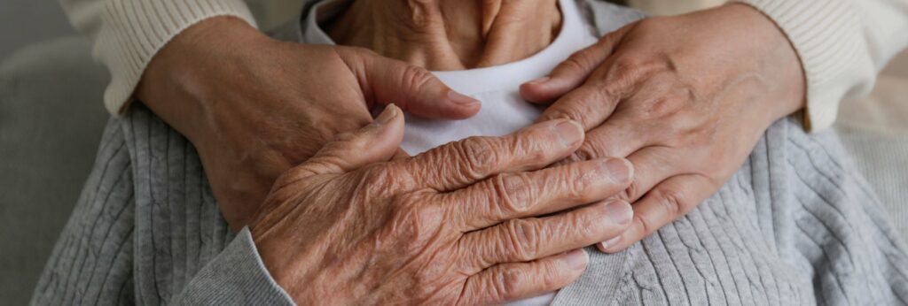 Main d'une personne âgée sur les mains d'un accompagnant