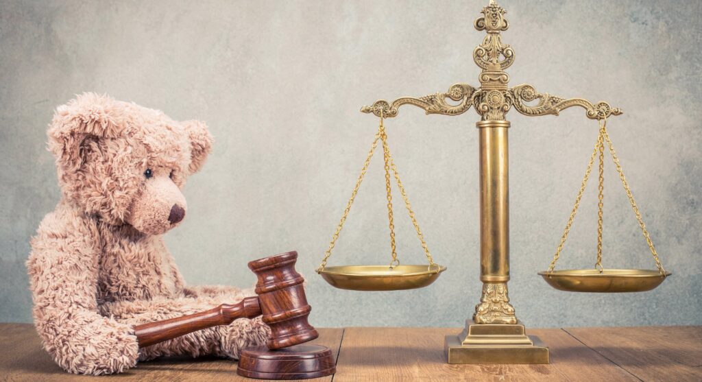 Balance de la justice et un ours en peluche avec le marteau